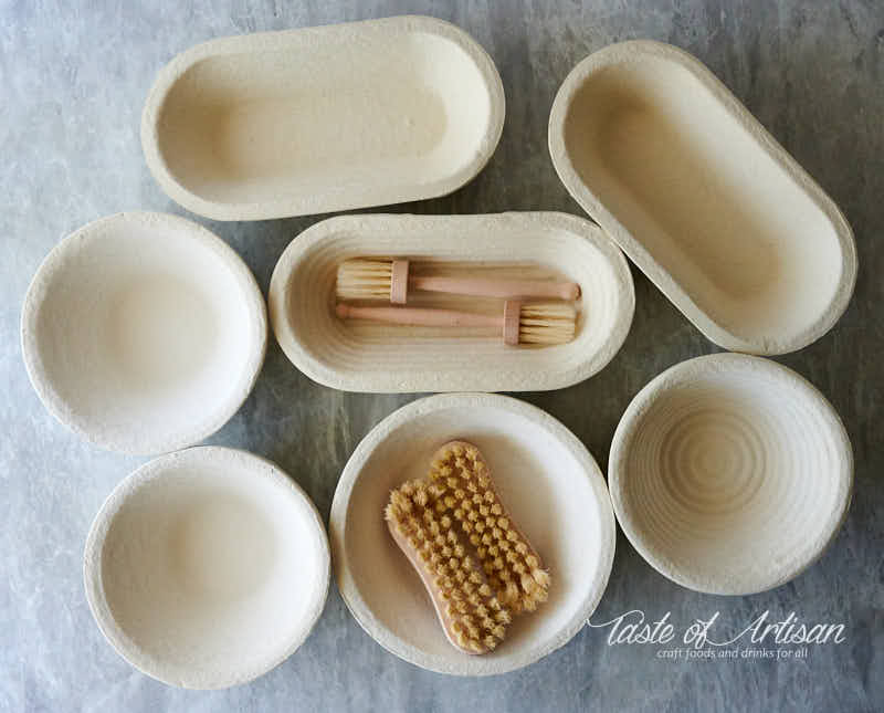 A variety of wood pulp proofing baskets and brushes on a table.