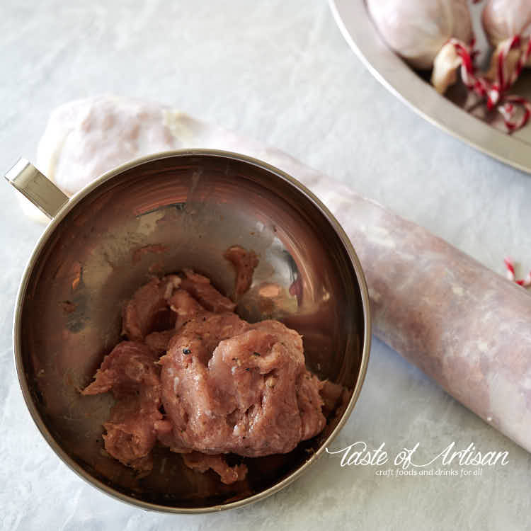 Stuffing leftover meat using a funnel.