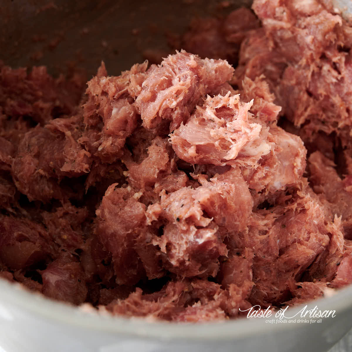 Meat for kielbasa fully mixed in a bowl. Close up view.