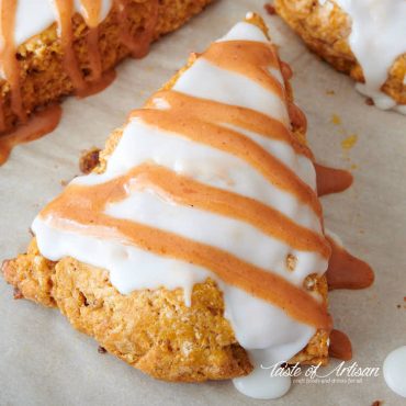 Pumpkin scones, covered with white glaze and stripes of orange glaze.