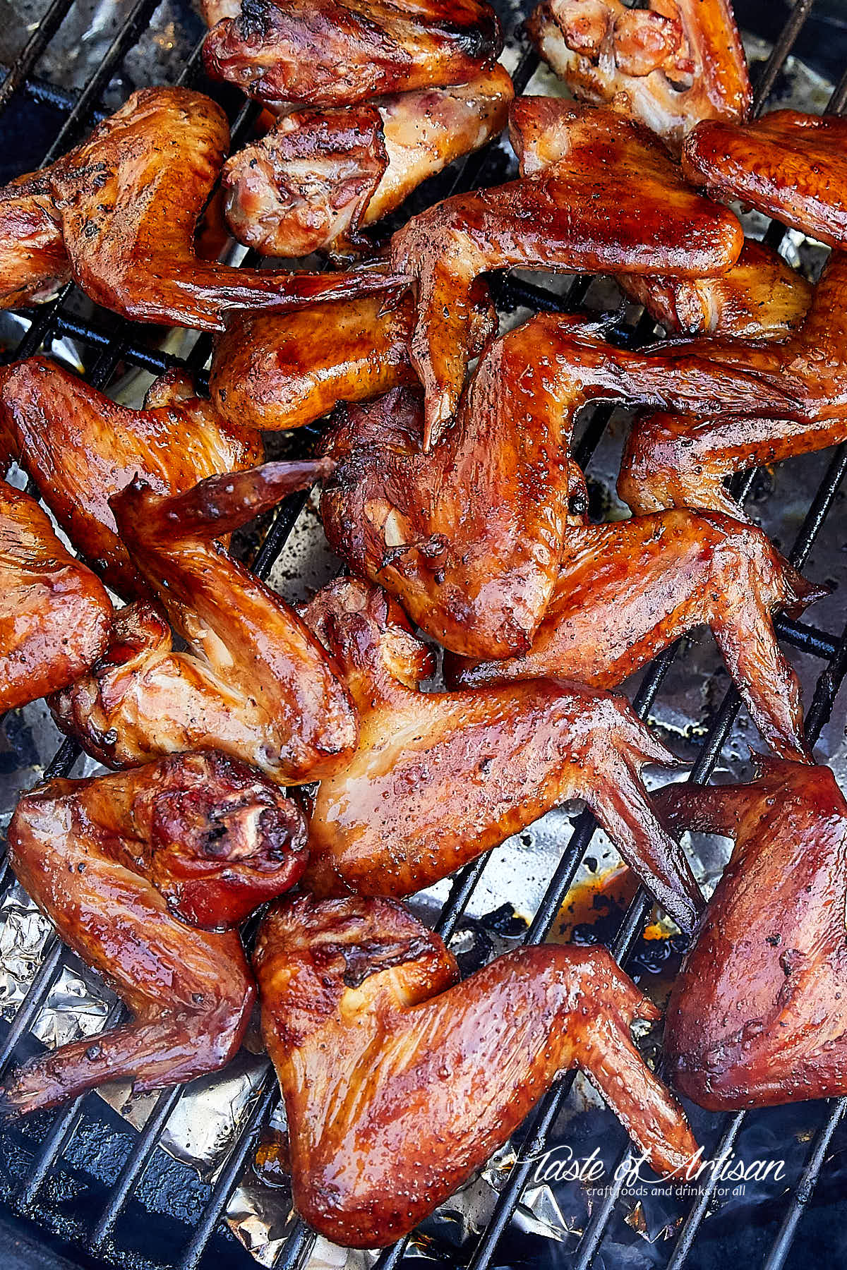 Golden-brown, smoked chicken wings on a smoker.