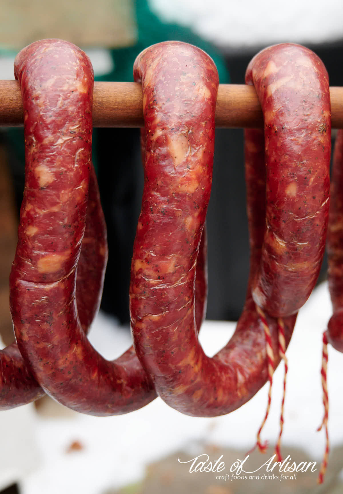 Smoked garlic sausage hanging on a stick.