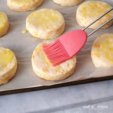 Brushing biscuit tops with egg wash.