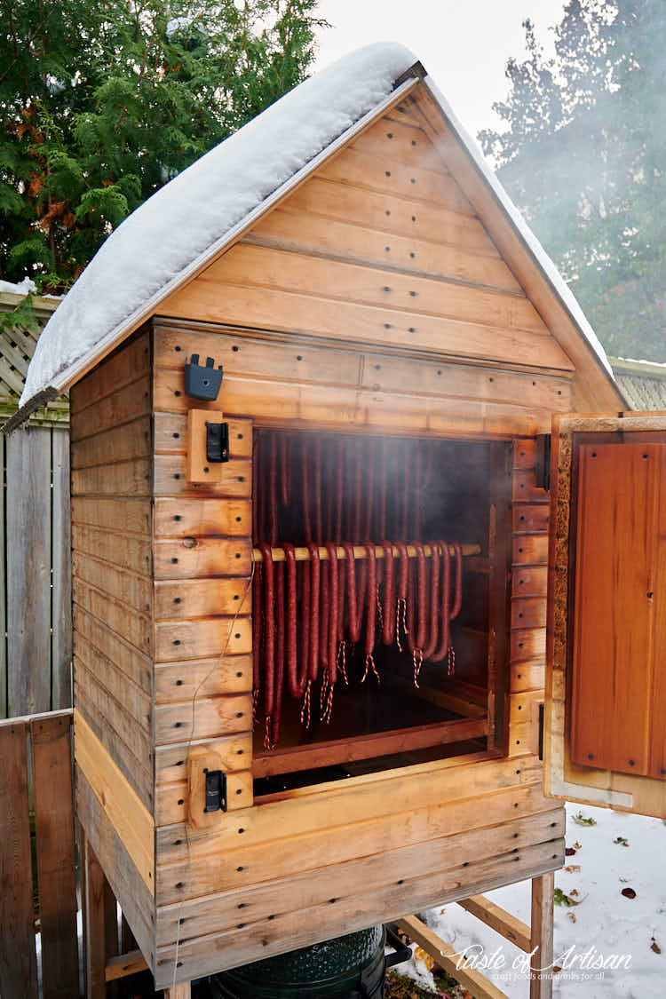 Kabanos smoking in a smokehouse, smoke coming out.