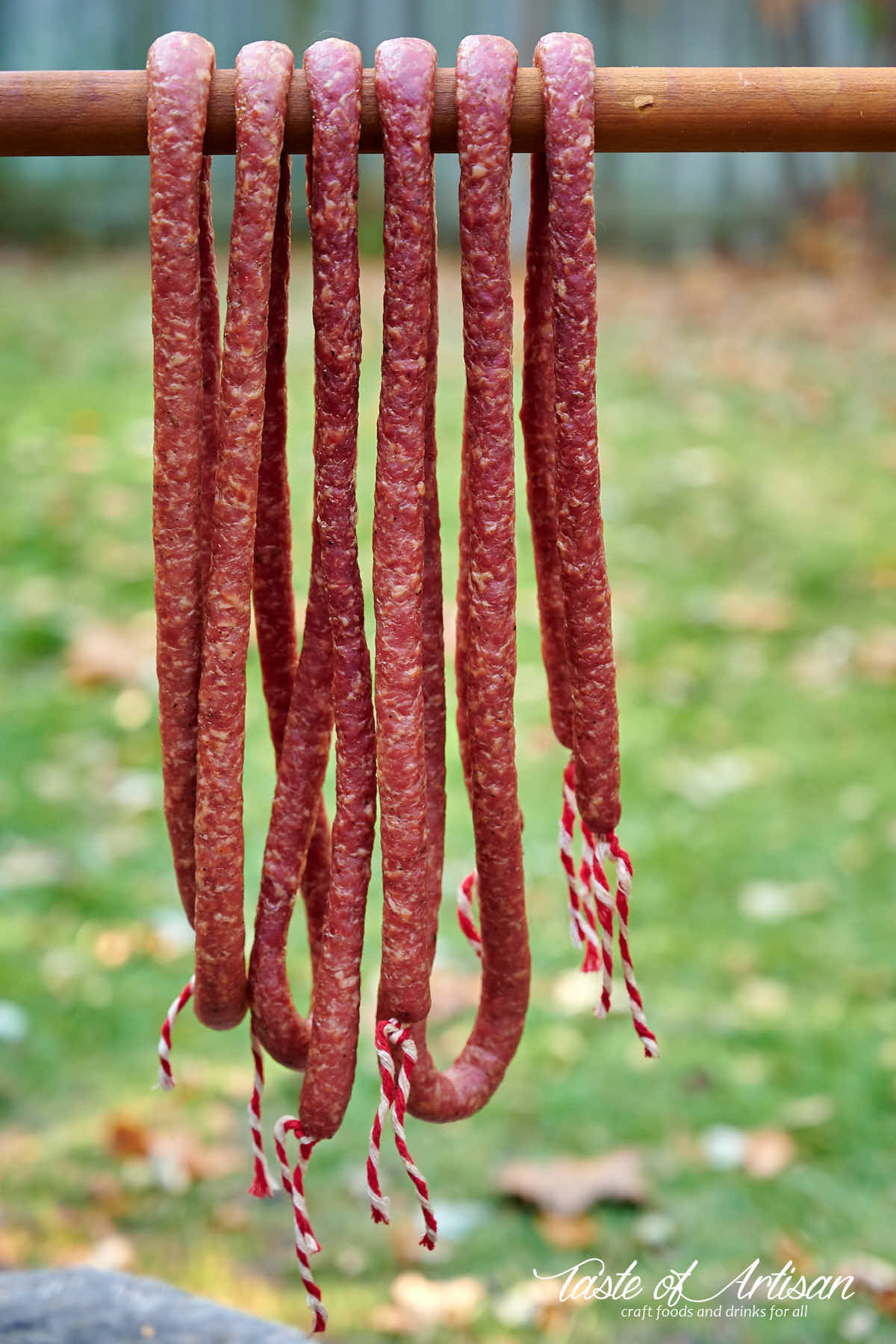 Kabanos sausage hanging from a smoke stick.