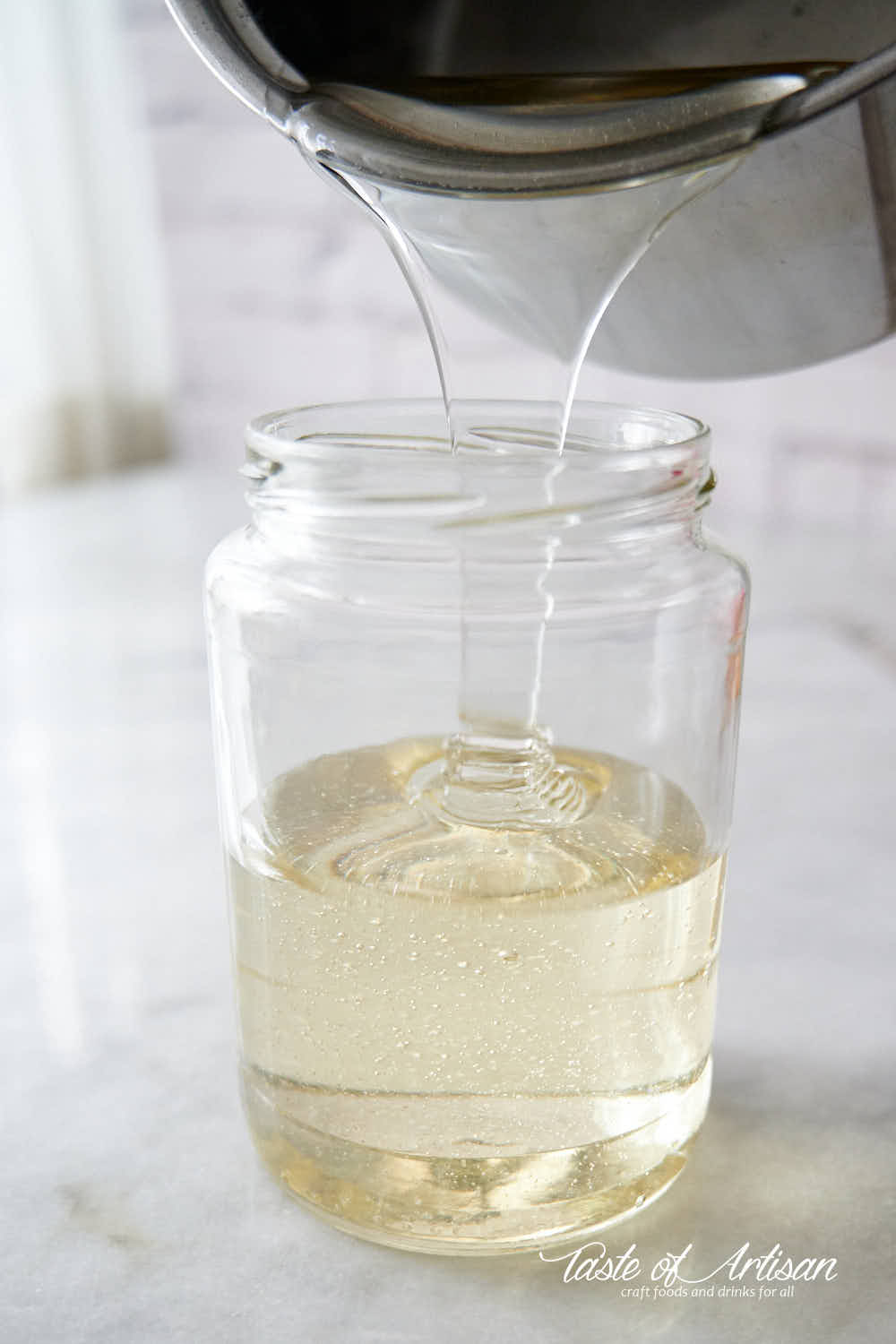 Pouring invert sugar in a jar.