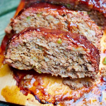 A slice of smoked meatloaf on a cedar plank.