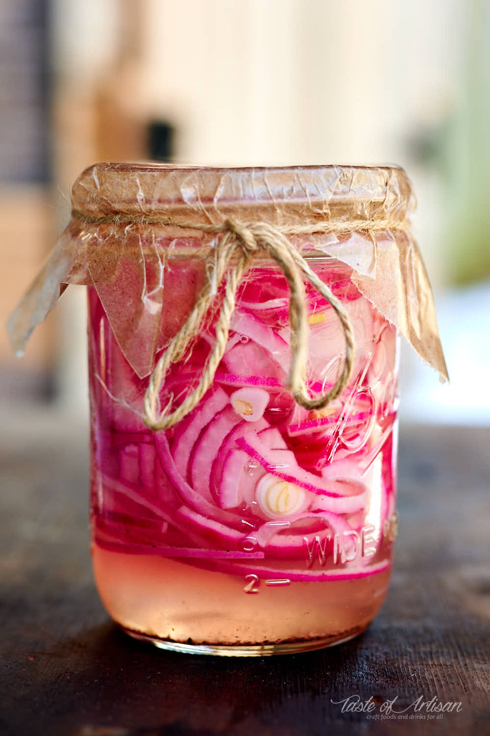 Sliced red onion in a jar with pickling juice.