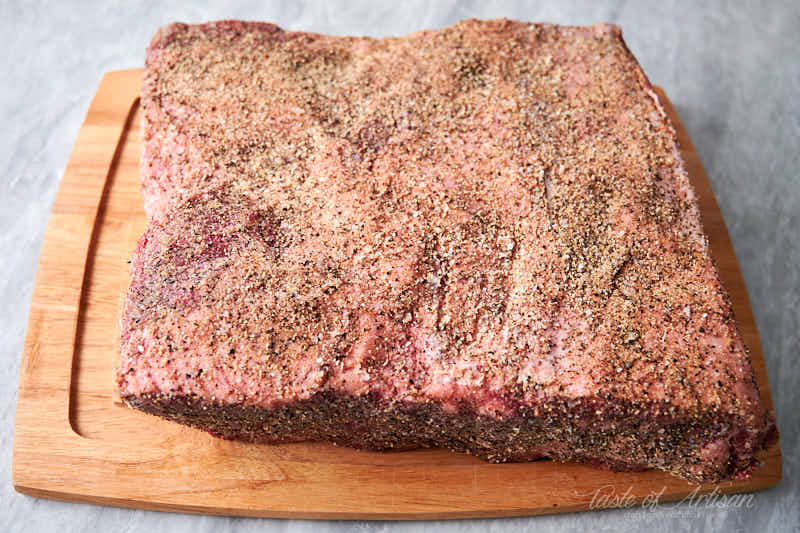 Raw beef short ribs covered in dry rub.