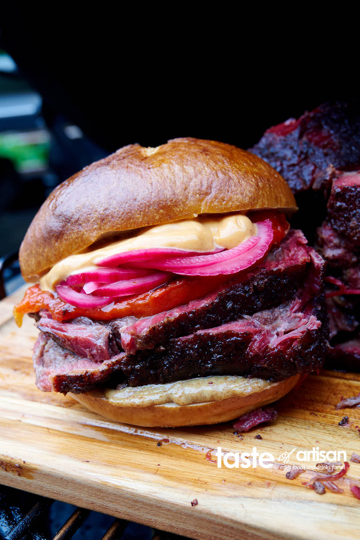 Smoked chuck roast sandwich made with homemade smoked chuck roast, pickled peppers and onions, chipotle aioli and a pretzel bun. So good!!!