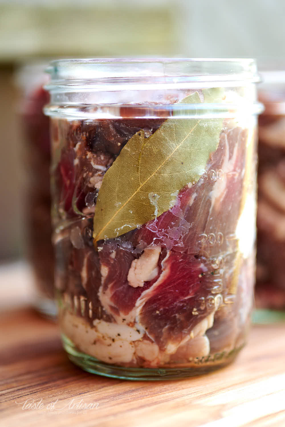 Chunks of raw beef in glass jars.