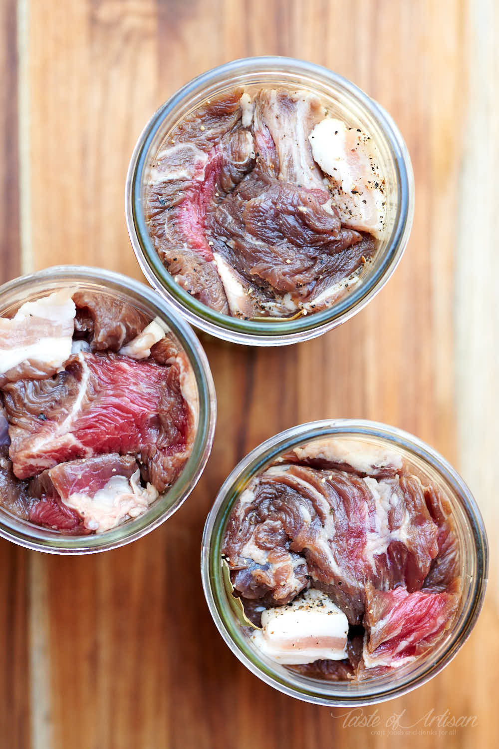 Stuffing beef chunks in canning jars.