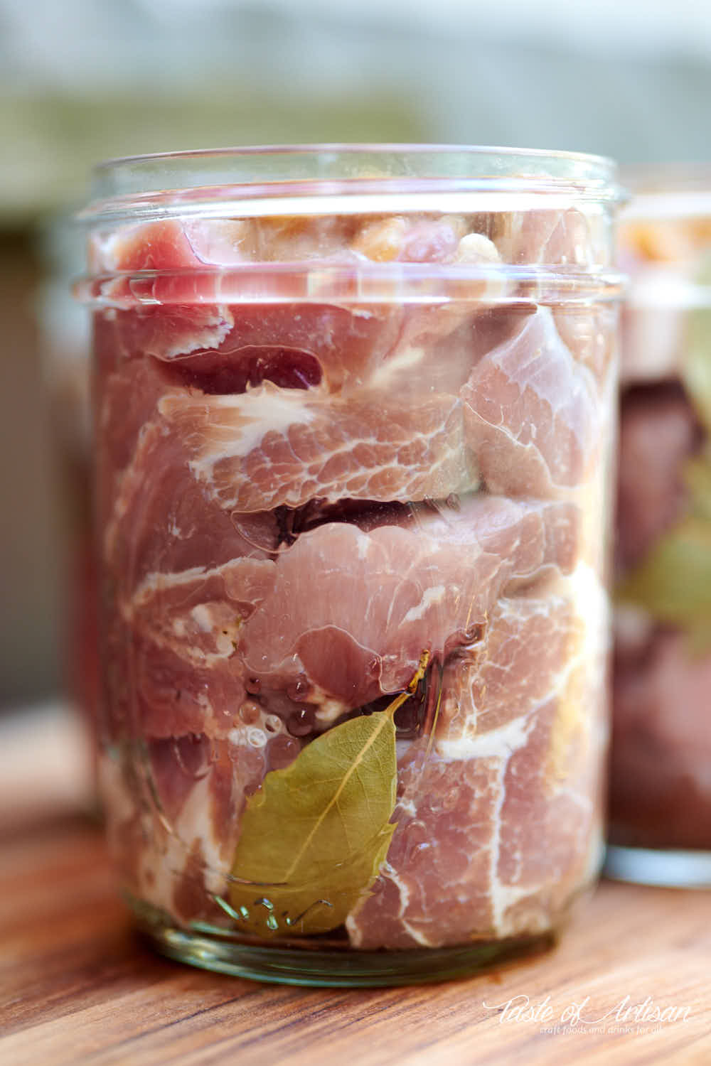 Chunks of raw pork in glass jars.