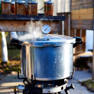 Steaming meat canner on gas burner.