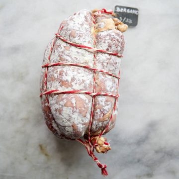 Thick Bergamo salami tied with twine and covered in white mold
