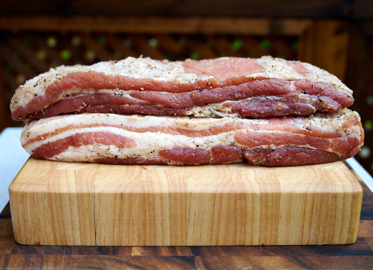 Meaty, well-cured bacon on a cutting board.