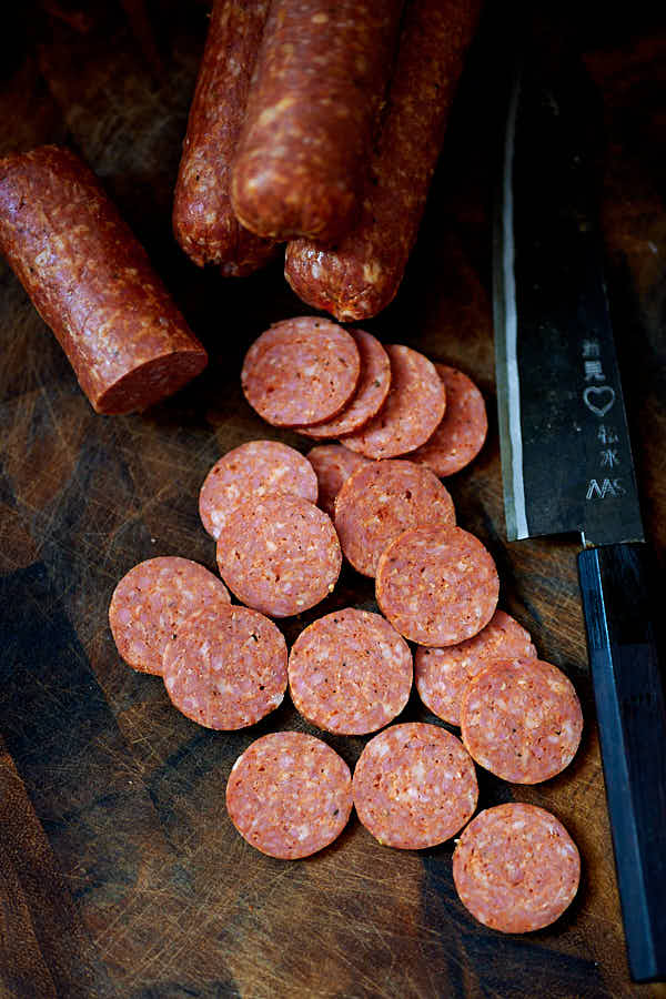 Sliced pepperoni on a cutting board.