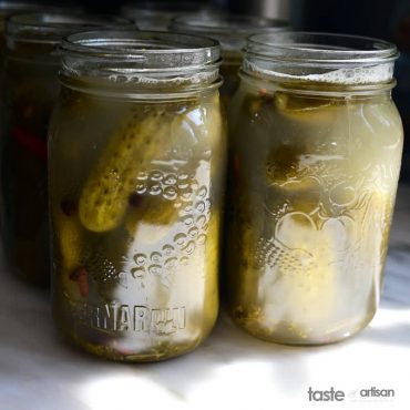Pickles in jars filled with pickling brine.