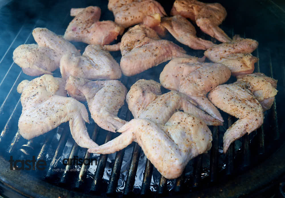 Smoking whole chicken wings over indirect heat.