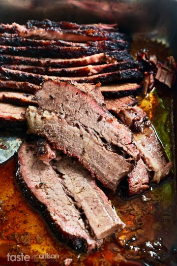 Slices of juicy smoked brisket in a pan.