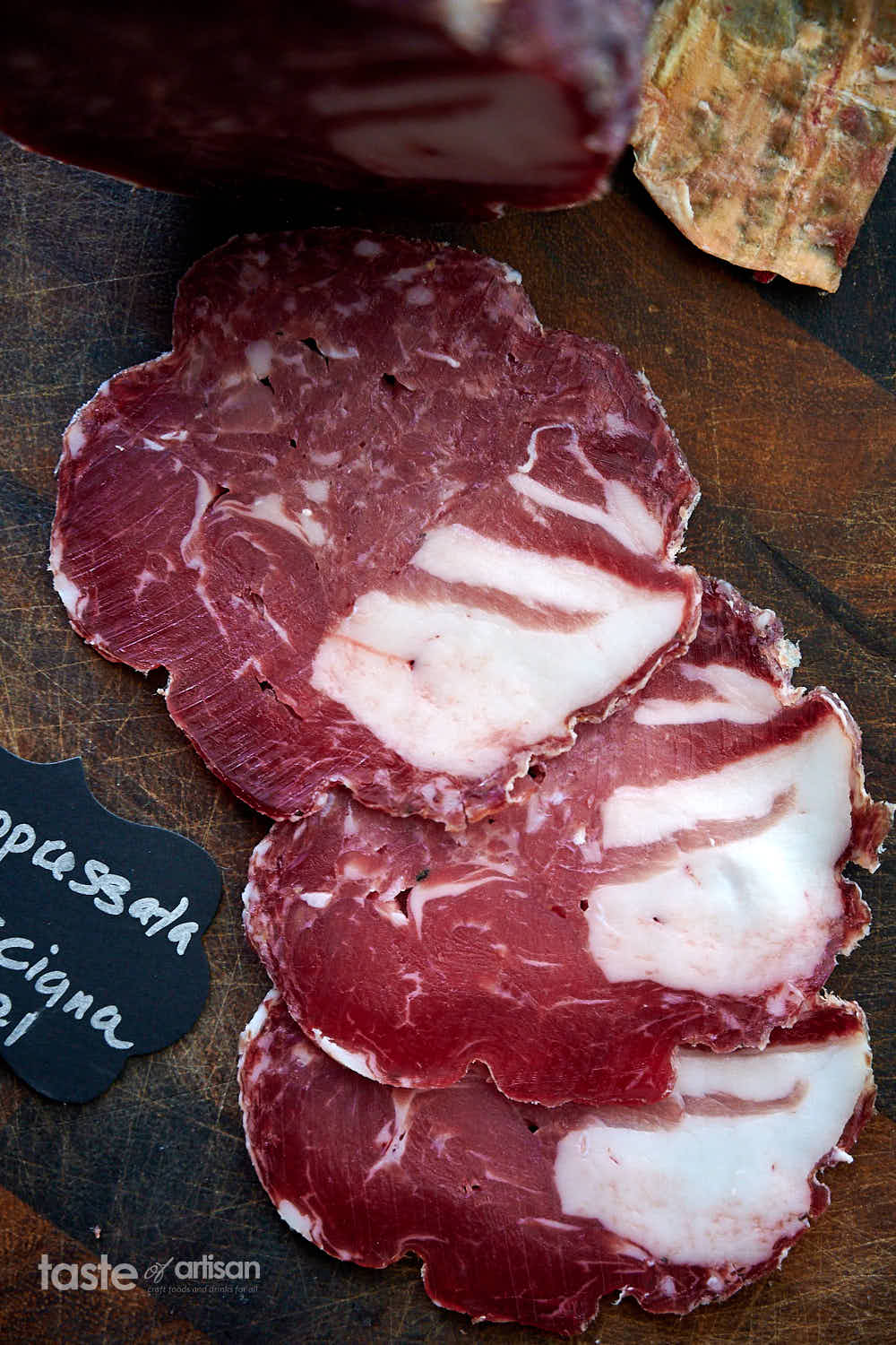 Soppressata salami slices on a cutting board.