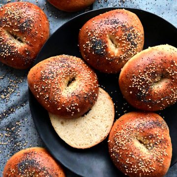 Sesame and poppy seed bagels on a plate.