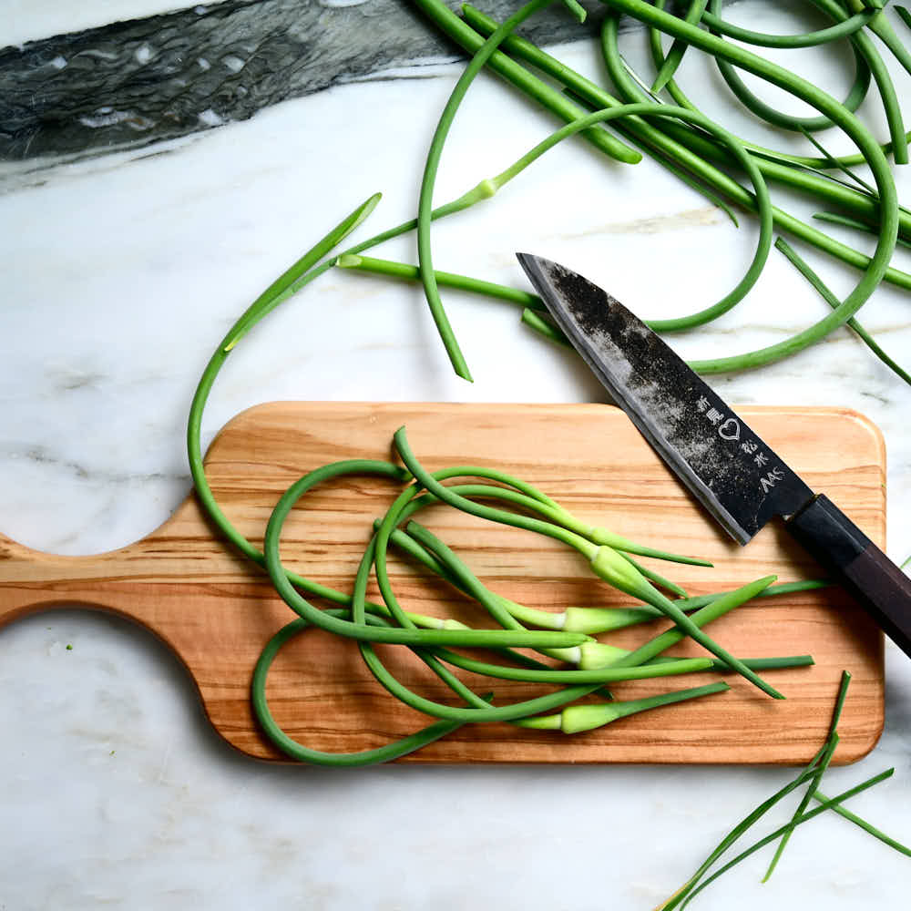 Garlic scapes on a cutting board.