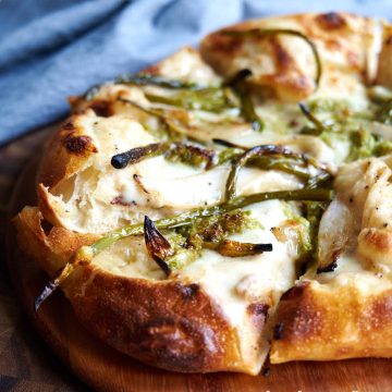 Neapolitan pizza with garlic scape pesto and roasted garlic scapes.