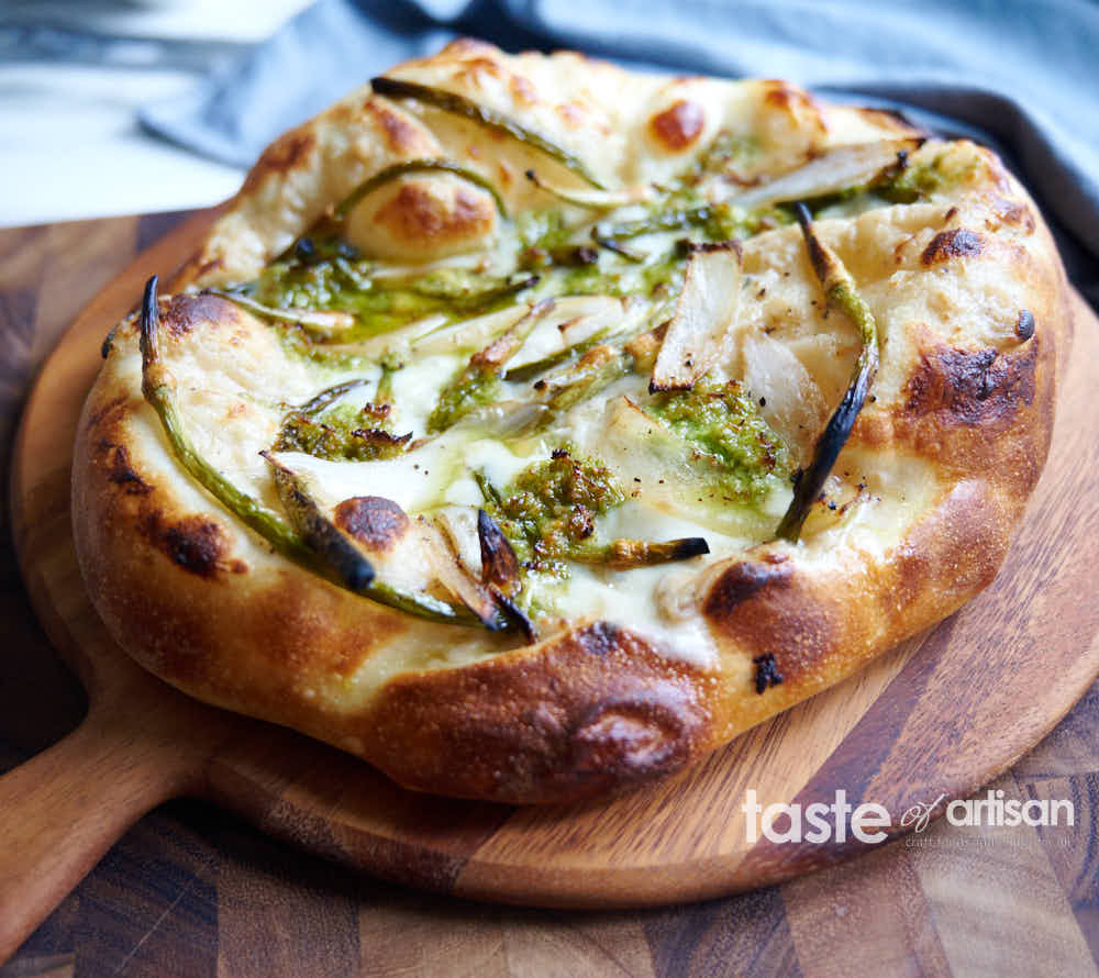 Neapolitan white sauce pizza made with garlic scapes, onion, and garlic scape pesto.