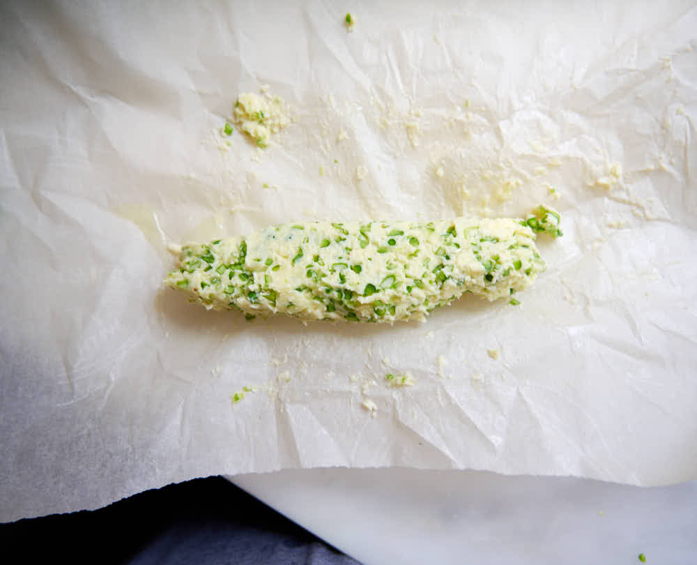 Compound butter log on parchment paper.