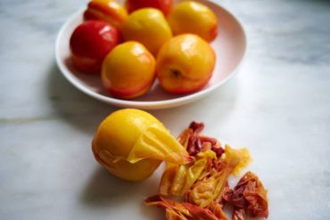 Peeling peaches after poaching.