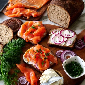 A board with sandwiches made with rye bread and homemade cold smoked king salmon