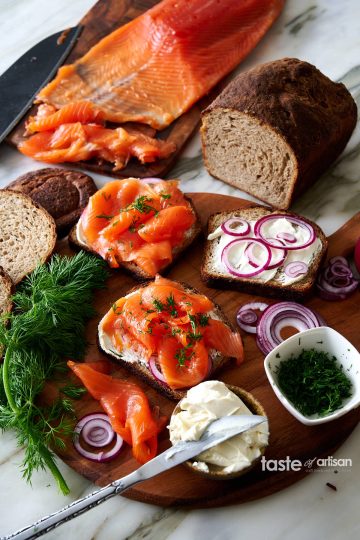 A board with sandwiches made with rye bread and homemade cold smoked king salmon