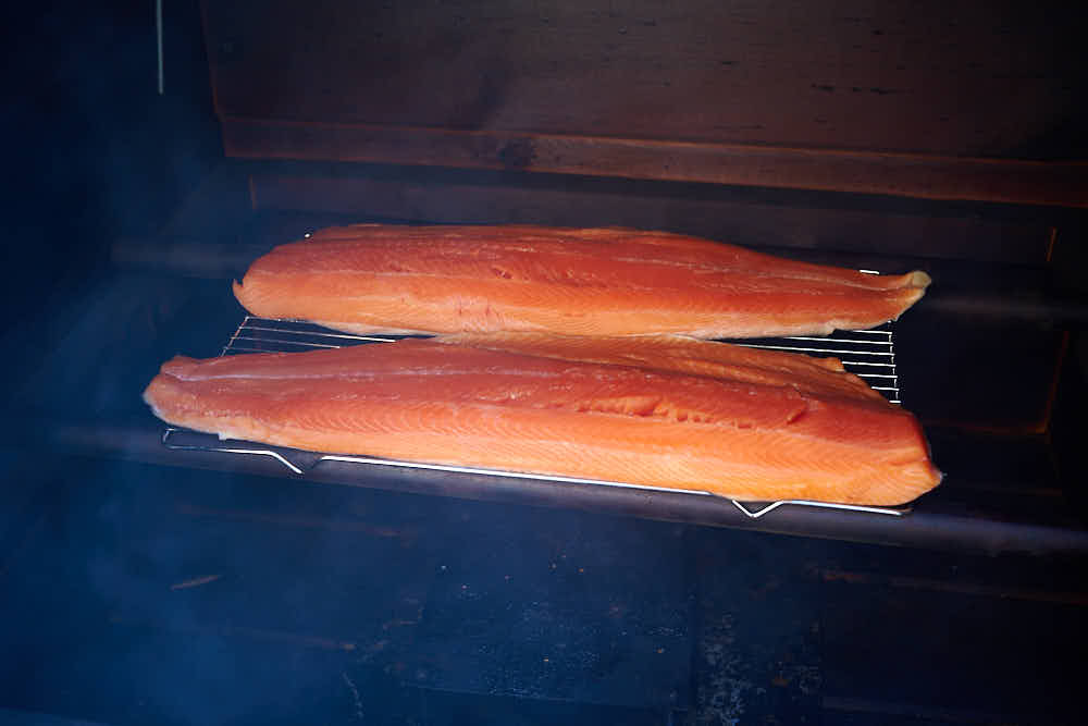 Smoking salmon in a smokehouse on a wire mesh.