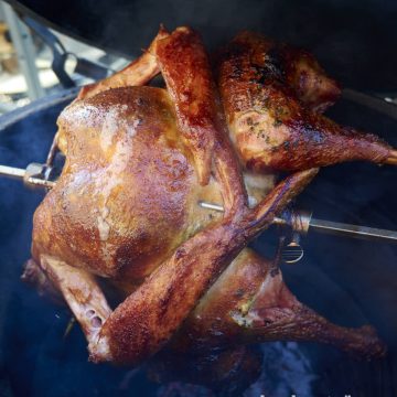 Turkey cooking on a rotisserie grill.