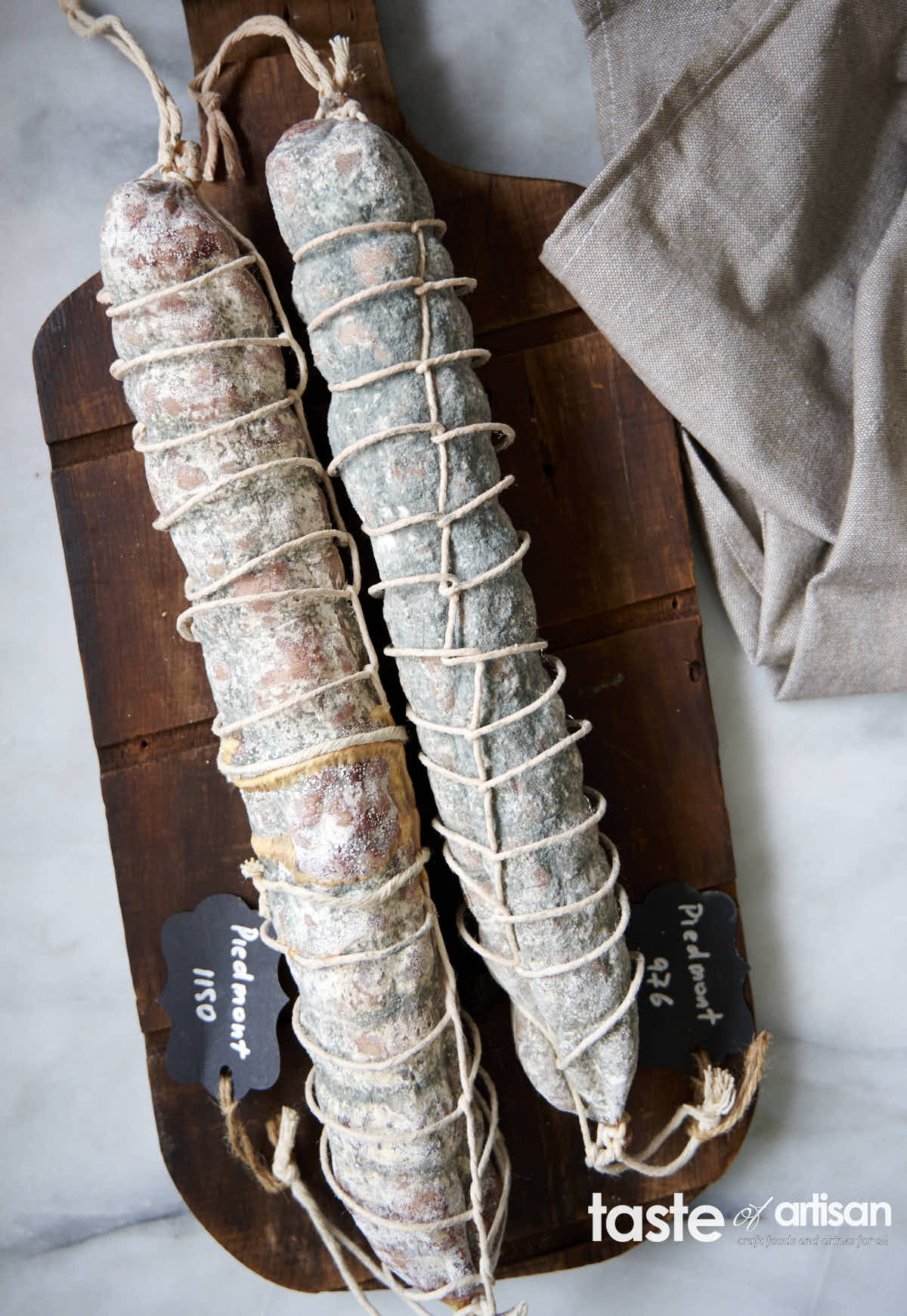 Curing Piedmont Salami in natural casings covered with white mold.